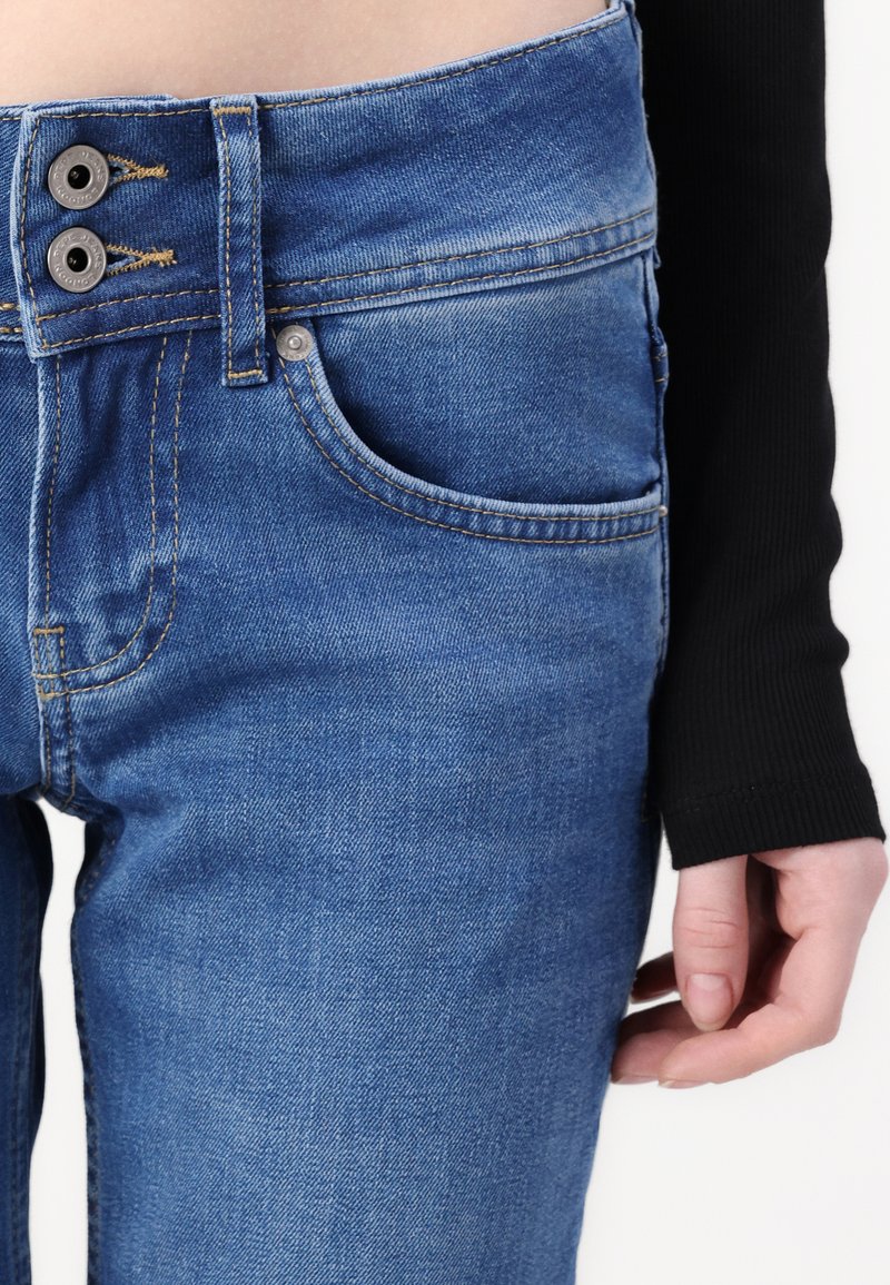 Blaue Jeans aus Denim besitzen einen Zwei-Button-Bund, kontrastierende Nähte und eine Vordertasche. Der Stoff hat eine glatte Textur und eine klassische Passform.