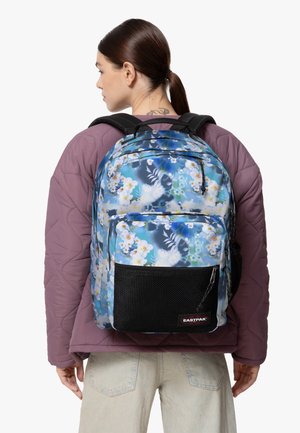 Mochila con un patrón floral en tonos azules y verdes, que cuenta con un bolsillo frontal de malla negra y correas acolchadas ajustables.