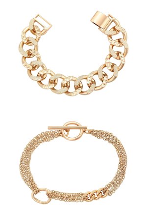 Twee gouden armbanden: één met grote, getextureerde schakels en een doossluiting, de andere met meerdere dunne kettinkjes en een togglesluiting.