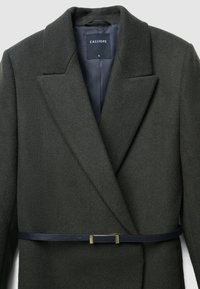 Manteau en laine vert foncé avec de larges revers et une ceinture noire fine avec boucle dorée à la taille, étiquette "CALLIOPE" taille petite à l'intérieur du col.