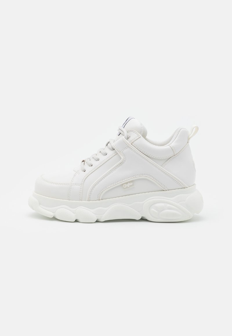 Baskets blanches épaisses avec semelle épaisse, lacets à l'avant, col rembourré et languette au talon, vues de côté extérieur.