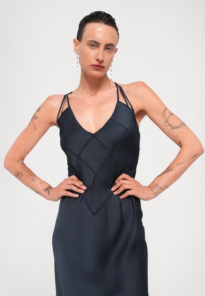 Marineblauwe slipdress met een diepe V-hals en diamantgestikte details. Beschikt over slanke bandjes en een strakke, gladde textuur.