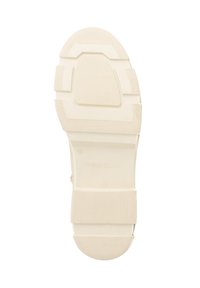 Beige rubber zool van een schoen met gestructureerde gripsecties en het reliëf merknaam "Travelin" en maatnummer 39.