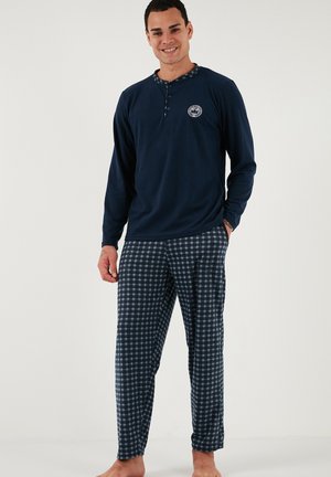 Maglia da pigiama a maniche lunghe blu navy con dettagli a bottoni e logo; pantaloni a quadri abbinati con motivo a scacchi. Tessuto morbido.