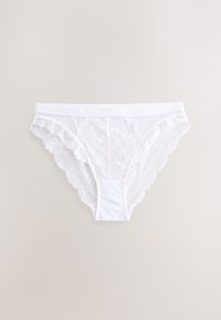 Ropa interior femenina estilo bikini de encaje blanco con patrones florales y bordes ondulados sobre un fondo neutro.