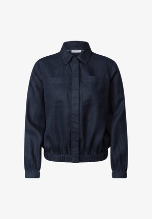 Sininen pellavapaita pitkillä hihoilla, nappisuljenta edessä, kaksi rintataskua ja joustava vyötärö. Sileä pinta ja muotoiltu istuvuus.