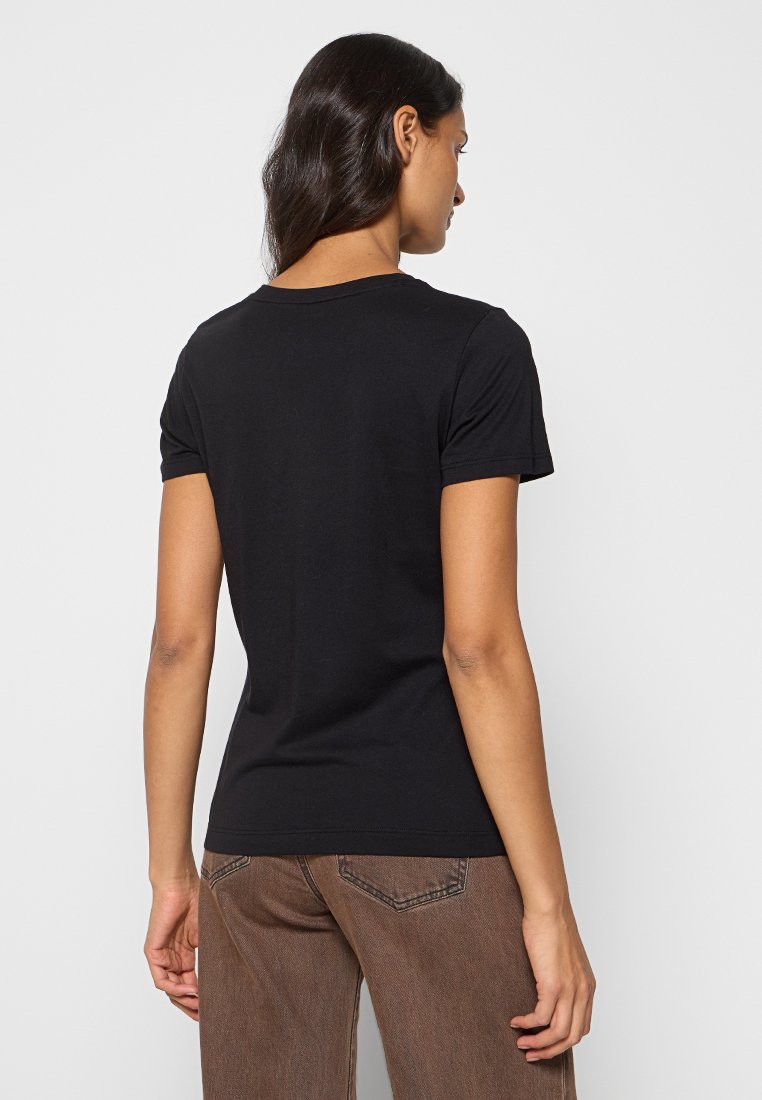 Camiseta negra de manga corta hecha de algodón, de diseño ajustado, cuello redondo, con una textura suave y detalles de costura en las costuras.