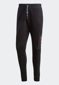 Černé sportovní joggery s elastickým pasem, camouflage šňůrkou na stažení a boční kapsou s oranžovým potiskem loga.