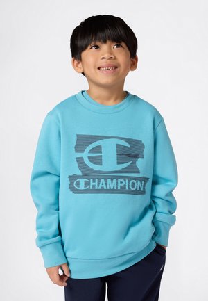 Turkisblå genser med rund hals, lange ermer og et trykt svart "C"-logo med "CHAMPION"-tekst på forsiden. Mykt, teksturert stoff.