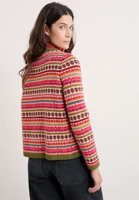 Pleteno pulover z večbarvnim geometrijskim vzorcem v roza, zeleni in črni barvi. Ima visok ovratnik in rebrast rob, z dolgimi rokavi.