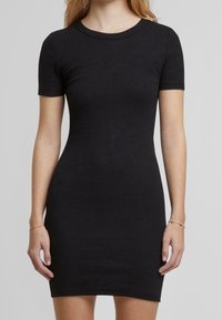 Robe courte noire à manches courtes côtelées avec un col rond, une forme ajustée et une texture lisse, conçue pour un ajustement près du corps. Aucun motif ou élément métallique visible.