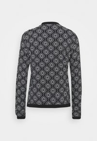 Zwart coltrui met lange mouwen en een wit diamanten patroon, voorzien van een ronde hals en ribgebreide manchetten. Zacht, gestructureerd materiaal door het gehele kledingstuk.