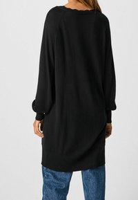 Maglione nero a maniche lunghe con vestibilità comoda, caratterizzato da polsini e orlo a costine e una scollatura rotonda. Il materiale sembra morbido e texture.