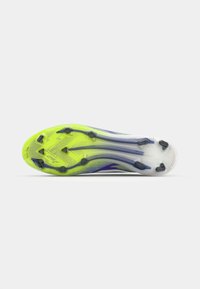 Athletic shoe sole in bright yellow and clear white, featuring black studs and textured pattern for traction and performance.