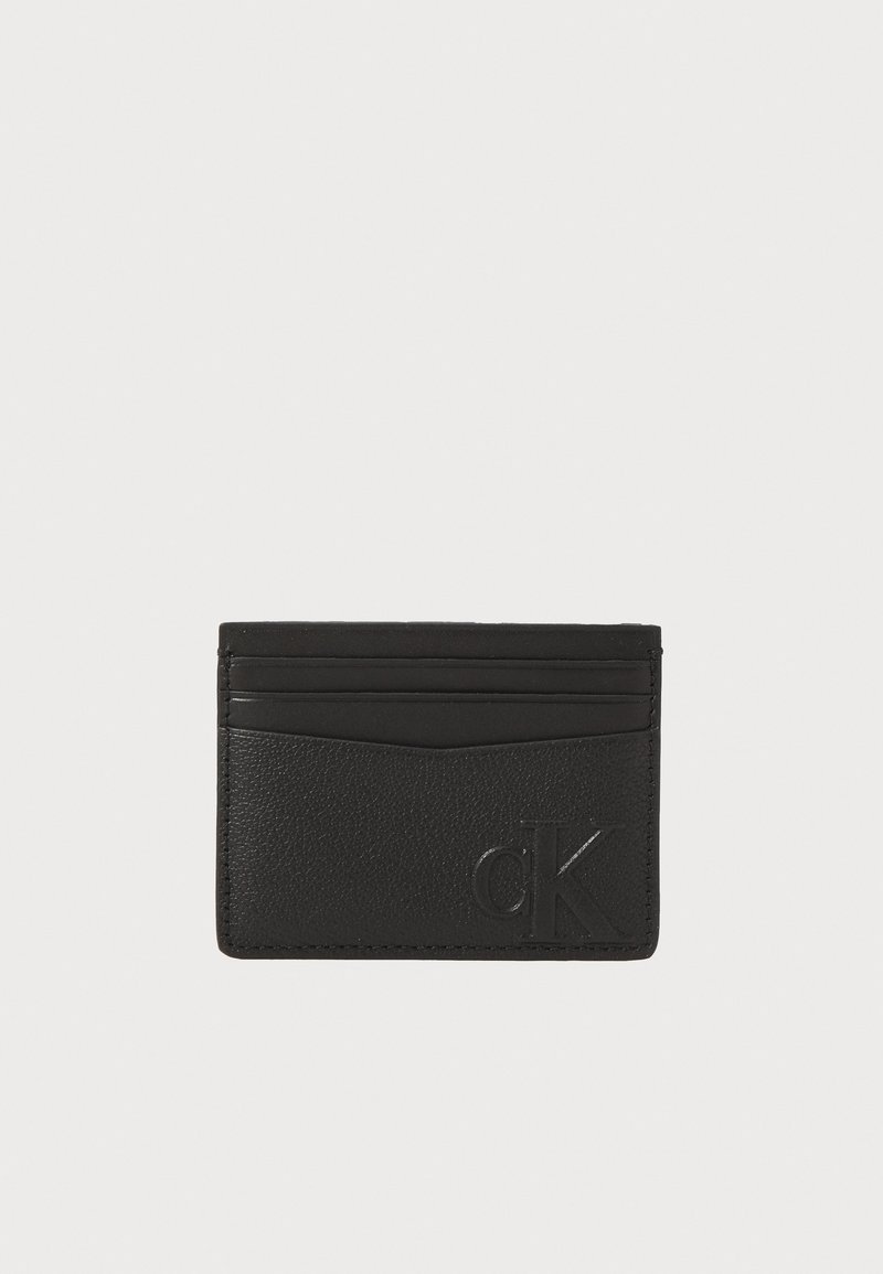 Black leather cardholder with a textured finish, featuring multiple card slots and an embossed logo on the front. Rectangular shape.