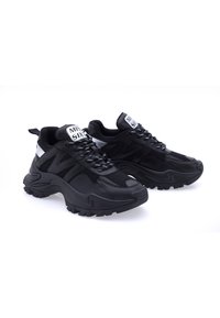 Sneaker sportive nere con tomaia in rete testurizzata, suola in gomma nera spessa e logo bianco a contrasto sulla linguetta. Design con lacci.