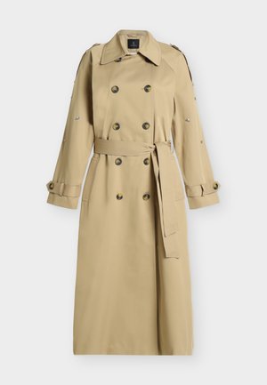 Beež topeltsõlmega trentšmantel vöö, nööpidega mansettrihmade, õlaepolaariide ja dekoratiivsete hõbedaste tihvtidega varrukatel.