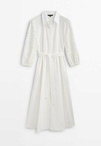 Robe midi blanche avec col, manches longues en dentelle ajourée, poignets élastiques et ceinture à nouer à la taille.