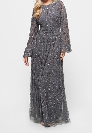 Abito lungo grigio con dettagli intricati di perline e paillettes, maniche lunghe trasparenti e gonna fluente.