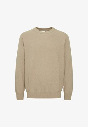 Pull en tricot beige avec un col rond, des manches longues et des poignets côtelés. La texture semble douce et légèrement épaisse. Pas de motifs ni d'accents visibles.