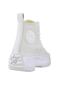 Zapatillas altas de cuero blanco con suela de goma texturizada, punta redondeada y parche con logo de estrella en el lateral. Cierre de cordones en la parte delantera con ojales de metal.