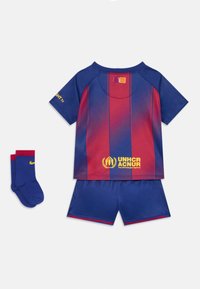 Conjunto deportivo infantil con temática de Barcelona en azul y rojo. Incluye una camiseta de manga corta con rayas, pantalones cortos y calcetas azules. Presenta logotipos.