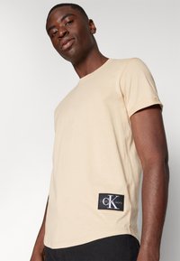 Calvin Klein Jeans BADGE TURN UP SLEEVE - T-shirt basic - warm sand