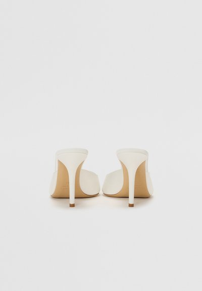 Mule bianchi con tacco alto e design open toe, parte superiore in pelle liscia e tacco sottile. Colore neutro con finitura opaca.