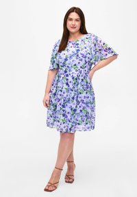 Blumenmusterkleid mit kurzen Ärmeln, hat einen helllilanen Hintergrund und grüne sowie blaue Blumenmuster, geraffte Taille und einen knielangen Rock.
