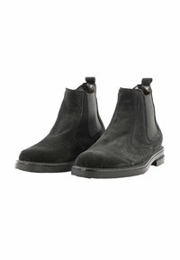Stivali Chelsea in suede nero con pannelli elastici laterali, punta rotonda, linguetta e suole in gomma piatta. La texture sembra morbida e opaca.