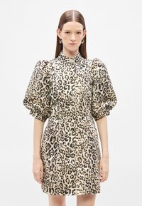 Sukienka w panterkę z bufkami, wysokim kołnierzem i dopasowanym krojem. Wykonana z teksturowanej tkaniny w beżowo-czarnym kolorze.