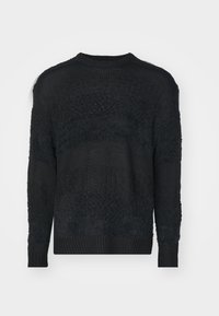 Black sweater made of textured knit fabric. Features a crew neckline, long sleeves, and varied patterns across the body and sleeves.