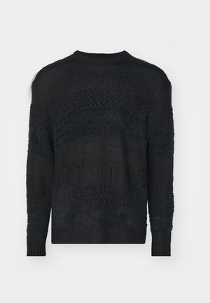 Must must, mis tekstuuriga kootud kangast. Omab ümmargust kaelaauku, pikki varrukaid ja erinevaid mustreid keha ja varrukate ulatuses.