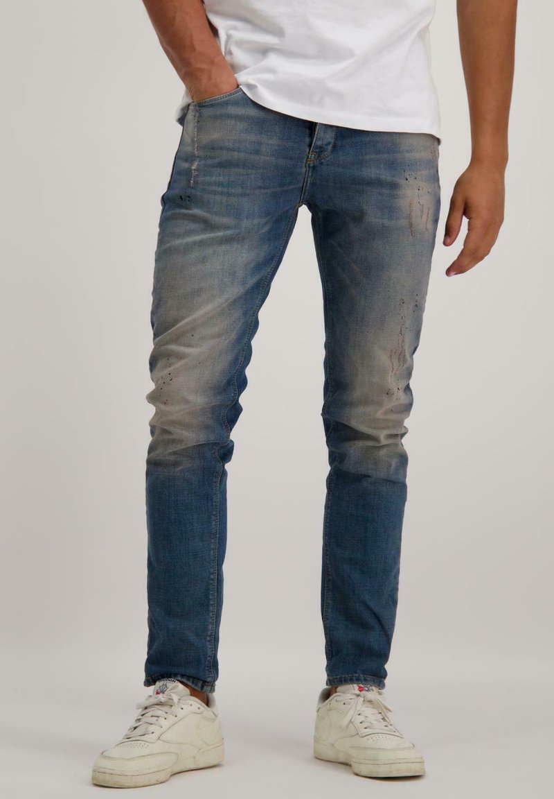 Denim jeans in een vervaagde blauwe wassingen met subtiele slijtage en een slim fit. Het materiaal is zacht met een lichte stretch, voorzien van standaard zakken.