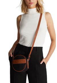 Musta, pyöreä crossbody-laukku, jossa on teksturoitu pinta, ruskeat nahkakoristeet ja säädettävä hihna. Edessä kohokuvioitu logo.