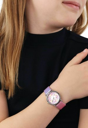 Child wearing black top with long blonde hair, showing wristwatch with pink and purple gradient strap and multicolored dial.