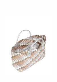 Vævet tote bag i beige og creme med sølv accenter. Har flettet tekstur og skinnende sølv håndtag. Indeholder en lynlåslomme indeni.