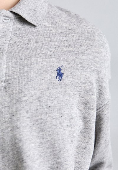 Gray polo shirt made of a textured knit fabric, featuring a blue embroidered logo on the left chest and a classic collar design.