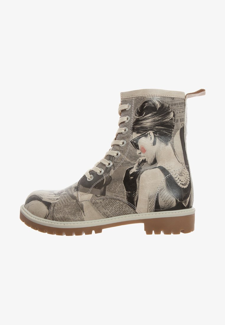 Lace-up ankle boot featuring a tan and grey newspaper print design with a black and white illustration. Rubber sole with textured tread.