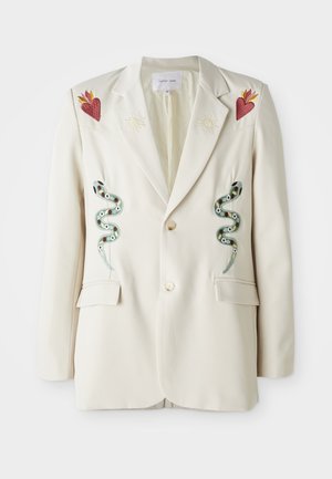 Kremfarget blazers med to broderte slanger, hjerte- og solmotiver på skuldrene. Har to frontlommer og to knapper. Glatt tekstur.