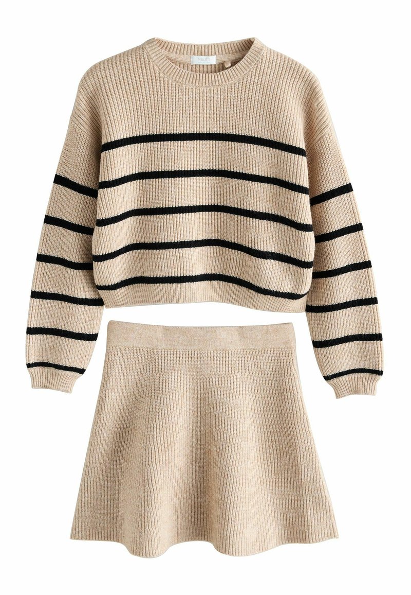 Beige strikket cropped sweater med sorte vandrette striber, parret med en matchende beige strikket flared nederdel, begge med ribbet tekstur.