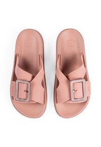Pink rubber slide sandals with a wide strap and a square metallic buckle detail. Smooth texture and contoured footbed design for comfort.