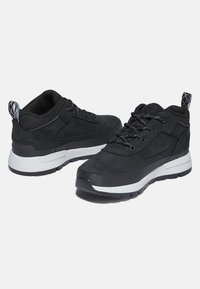 Zapatillas deportivas negras con parte superior de ante, detalles de malla y suela de goma texturizada. Presentan cordones negros y una mediasuela blanca.