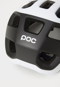 Mustvalge jalgrattakiiver ventilatsiooniavadega, sileda plastpinnaga, tekstuurse sisepadjaga ja esiosas silmapaistev "poc" logo.