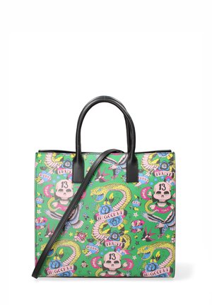 Sac fourre-tout vert avec un design imprimé vibrant représentant des skulls, des serpents, des fleurs et des étoiles. Poignées noires et sangle amovible.