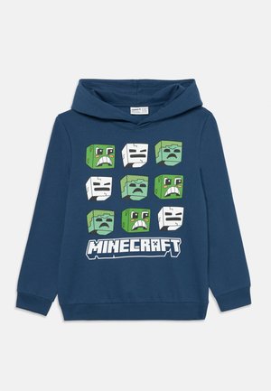 Mörkblå huvtröja med nio Minecraft-karaktärsansikten i ett rutnät och Minecraft-logotypen under designen.