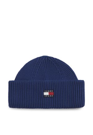 Navy blue knitted beanie with folded cuff and rectangular Tommy Jeans logo patch in red, white, and black on front center.