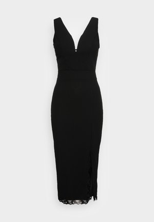 Robe noire sans manches avec décolleté en V, silhouette ajustée et dentelle au niveau de l'ourlet. Présente une fente sur le côté pour un détail supplémentaire.