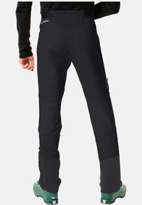 Pantalones de esquí negros con un diseño aerodinámico, que presentan paneles en contraste, cremalleras laterales y una cinturilla alta. Adecuados para climas fríos.