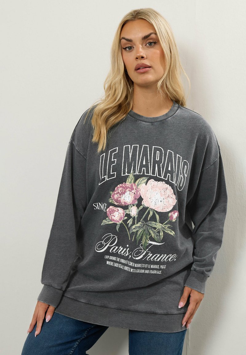 Sudadera gris de manga larga, con un gráfico floral y el texto "LE MARAIS" en blanco, de corte holgado, con textura suave y puños acanalados.